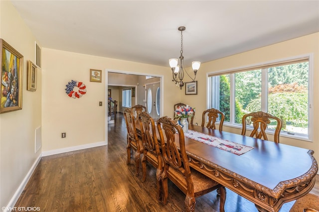 dining space with dark wood-style floors, baseboards, visible vents, and a notable chandelier