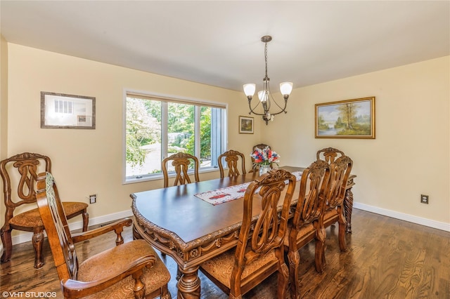 dining space with dark wood-style floors, a chandelier, and baseboards