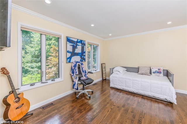 bedroom with multiple windows, visible vents, wood finished floors, and ornamental molding