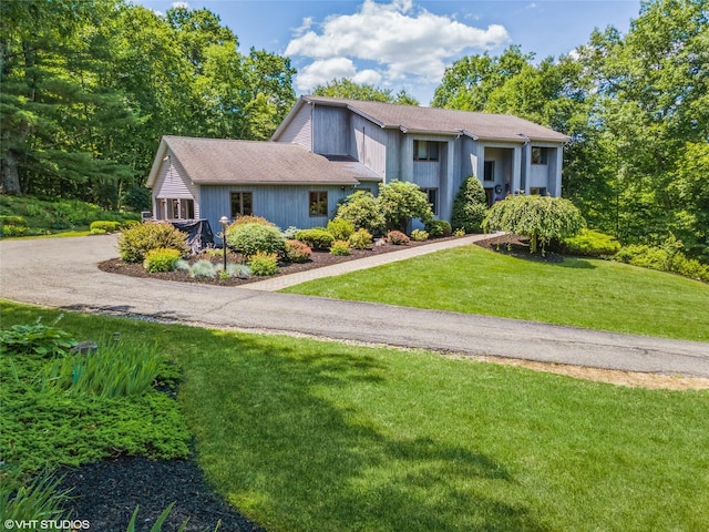 view of front of property with aphalt driveway and a front lawn