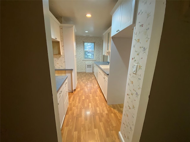 kitchen featuring sink, light hardwood / wood-style floors, and white cabinets