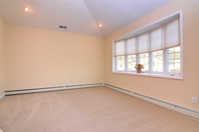 empty room featuring vaulted ceiling, light colored carpet, and a baseboard radiator