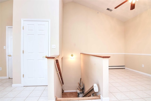 stairway featuring tile patterned flooring, a baseboard heating unit, lofted ceiling, and ceiling fan