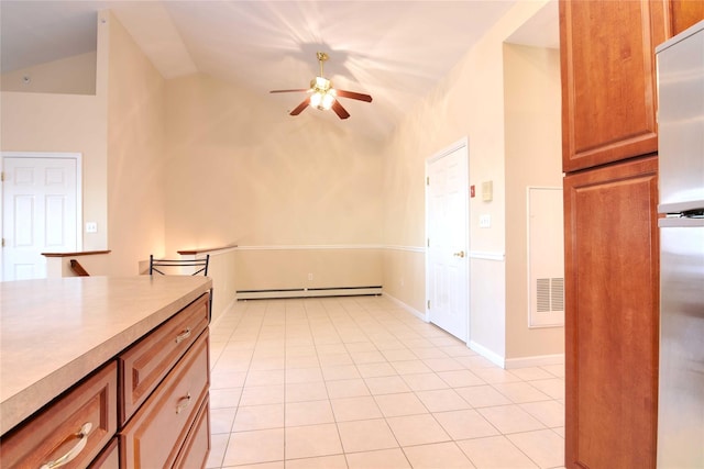 kitchen featuring light tile patterned floors, stainless steel refrigerator, ceiling fan, vaulted ceiling, and a baseboard radiator