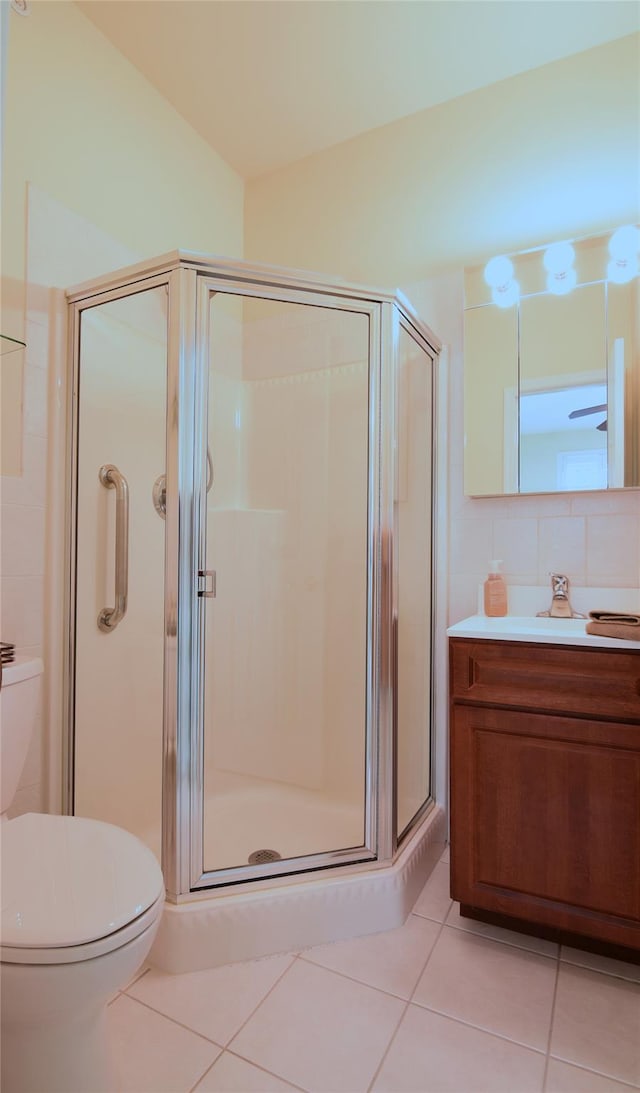 bathroom with tile patterned flooring, toilet, vanity, and walk in shower