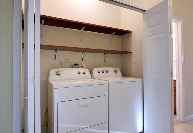 clothes washing area featuring washing machine and dryer and light tile patterned floors