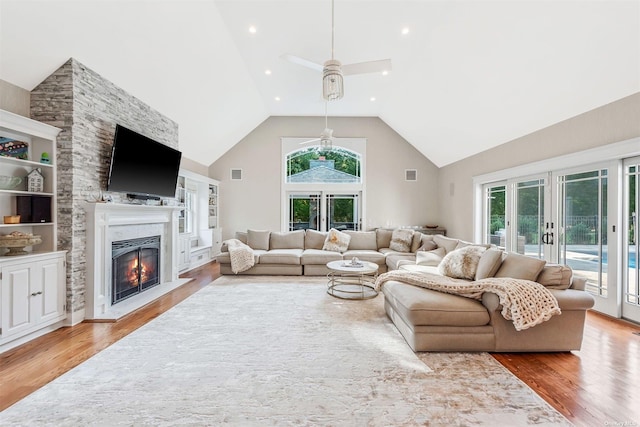 living room featuring wood-type flooring, ceiling fan, high vaulted ceiling, and french doors