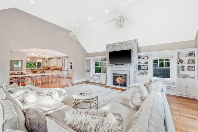 living room with high vaulted ceiling, light hardwood / wood-style floors, and ceiling fan