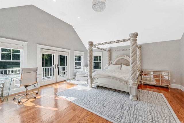 bedroom featuring wood-type flooring, access to outside, high vaulted ceiling, and french doors