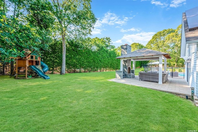 view of yard featuring a gazebo, an outdoor living space with a fireplace, a playground, and a patio