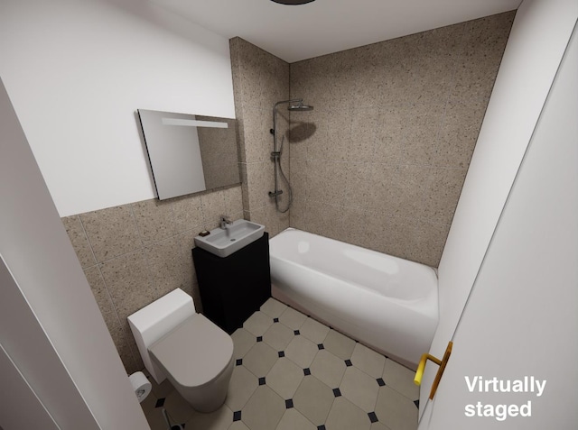 full bathroom featuring vanity, tiled shower / bath, tile walls, and toilet