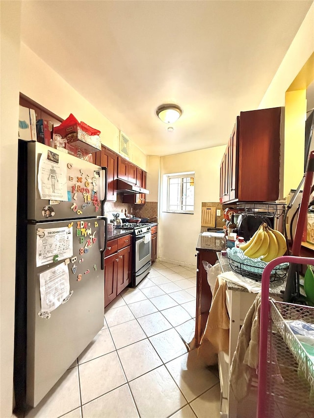 kitchen with appliances with stainless steel finishes, sink, light tile patterned floors, and backsplash