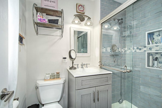 bathroom featuring walk in shower, vanity, and toilet