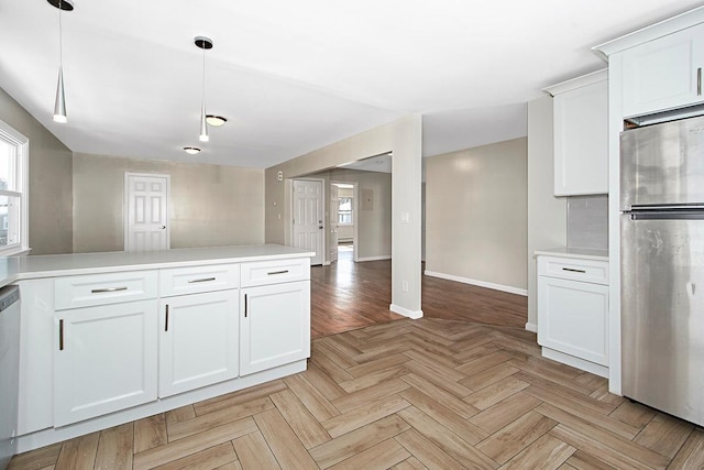 kitchen featuring white cabinetry, appliances with stainless steel finishes, light parquet flooring, and decorative light fixtures