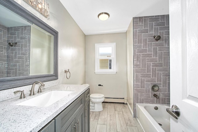 full bathroom with a baseboard radiator, toilet, vanity, and tiled shower / bath