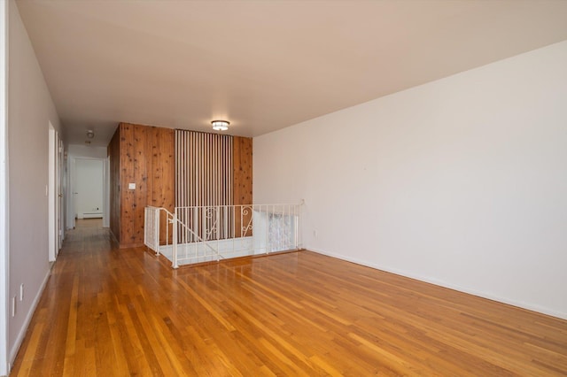 empty room featuring a baseboard radiator and hardwood / wood-style floors