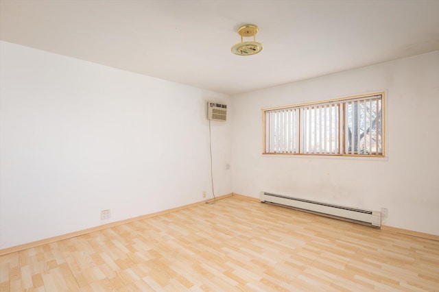 unfurnished room with an AC wall unit, a baseboard heating unit, and light hardwood / wood-style flooring