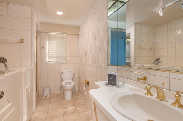 bathroom featuring tile patterned flooring, vanity, tile walls, and toilet