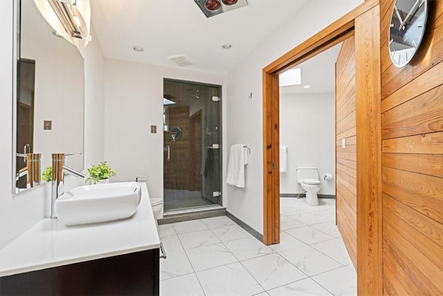 bathroom featuring vanity, toilet, and a shower with door