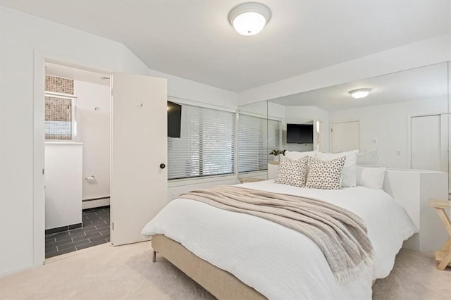 bedroom with a baseboard radiator, carpet floors, and ensuite bathroom