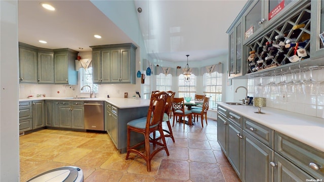 kitchen featuring decorative light fixtures, dishwasher, sink, and a wealth of natural light