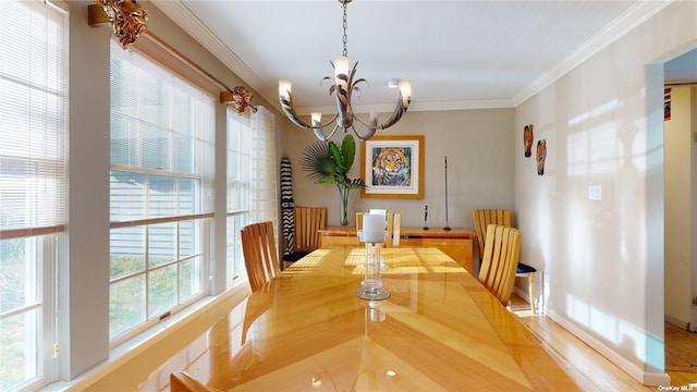 dining space with crown molding and an inviting chandelier