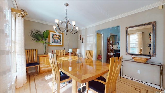 dining space featuring crown molding, light hardwood / wood-style floors, and a notable chandelier