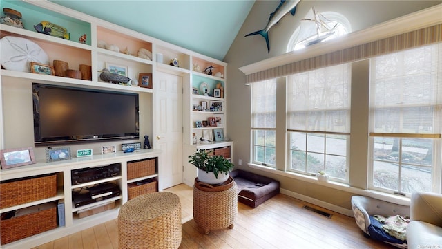 living area featuring lofted ceiling and light hardwood / wood-style flooring