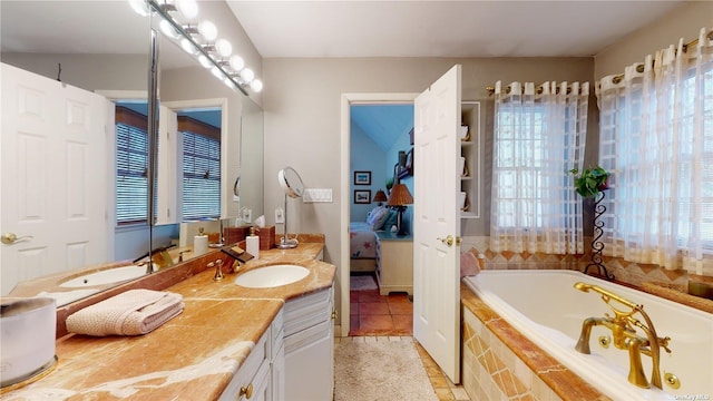 bathroom with tiled tub, vanity, and a wealth of natural light