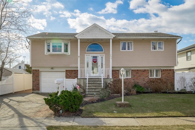 bi-level home featuring a garage and a front lawn