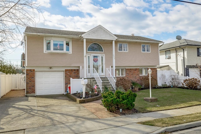 bi-level home with a garage and a front lawn