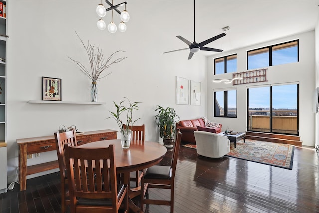 dining area featuring a high ceiling, dark hardwood / wood-style floors, and ceiling fan