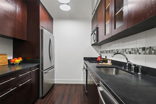 kitchen featuring sink, appliances with stainless steel finishes, dark brown cabinets, dark hardwood / wood-style flooring, and decorative backsplash