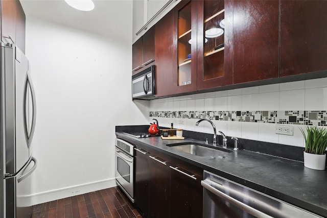 kitchen featuring sink, backsplash, dark wood-type flooring, and stainless steel appliances