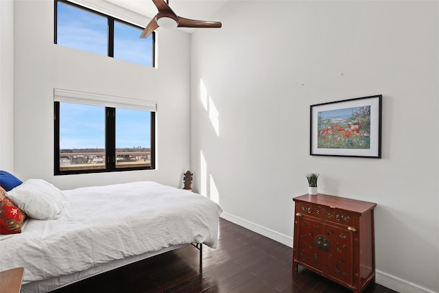 bedroom with multiple windows and dark hardwood / wood-style floors