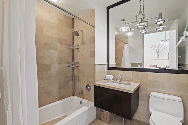 full bathroom with tile walls, vanity, toilet, and shower / bath combo