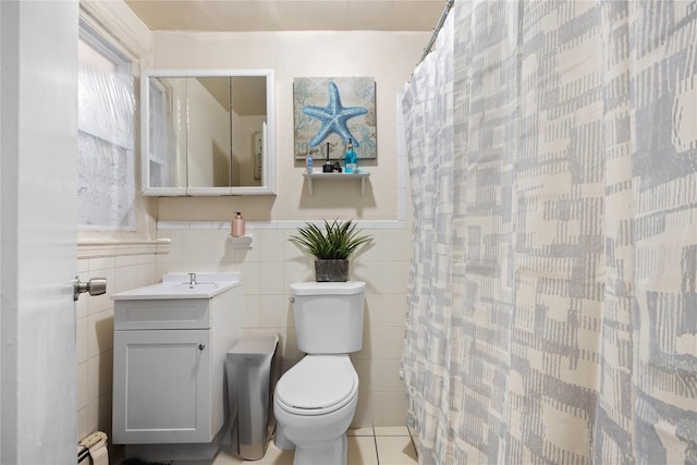 bathroom with toilet, tile walls, a baseboard radiator, vanity, and curtained shower