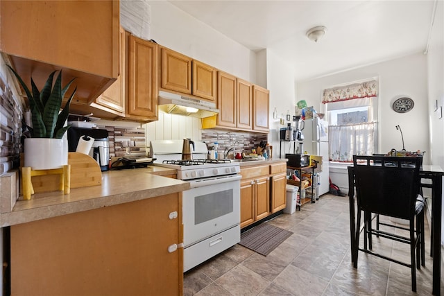 kitchen with sink, backsplash, and white gas range oven