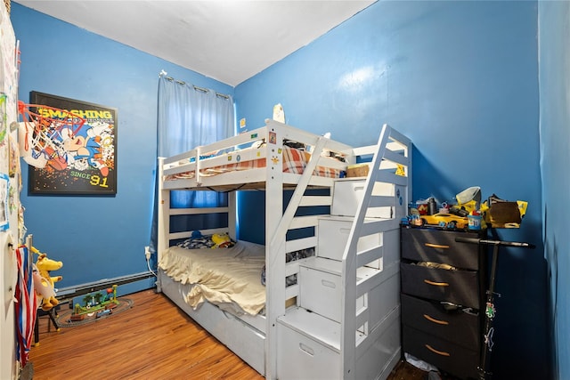 bedroom featuring hardwood / wood-style flooring and baseboard heating