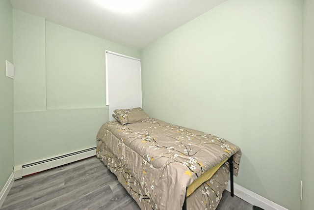 bedroom with hardwood / wood-style floors and a baseboard radiator