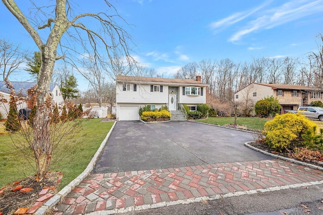 split foyer home featuring a garage and a front lawn