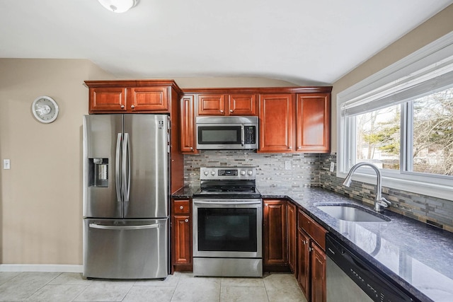 kitchen featuring tasteful backsplash, sink, stainless steel appliances, and dark stone counters