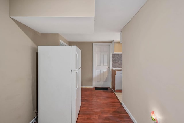 kitchen with white refrigerator, tasteful backsplash, and dark hardwood / wood-style floors