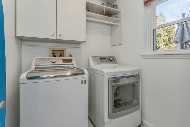 washroom with washing machine and dryer and cabinets