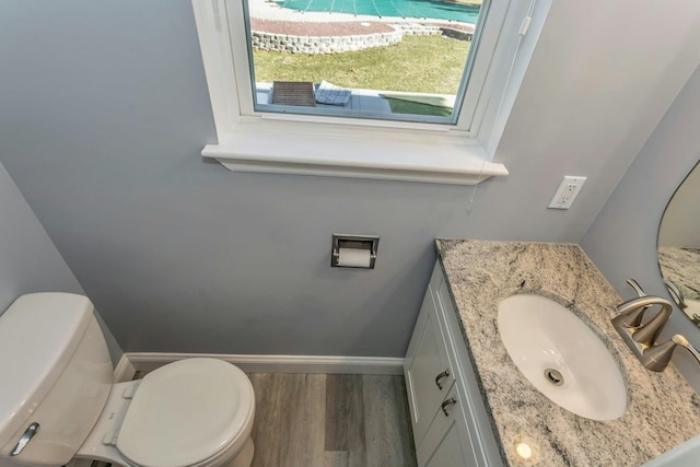 bathroom featuring vanity, hardwood / wood-style flooring, and toilet