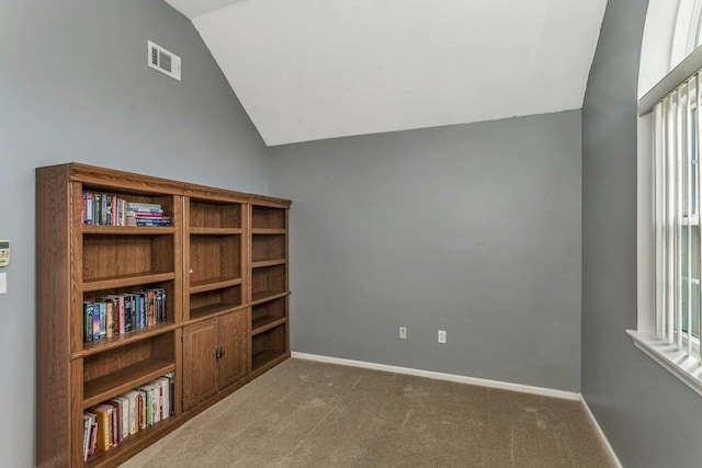 empty room featuring carpet flooring and vaulted ceiling