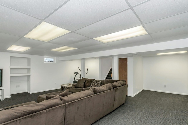 carpeted living room with a paneled ceiling and built in features