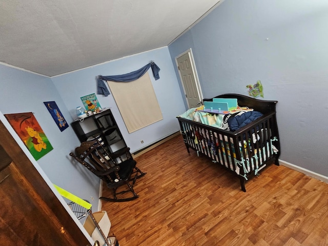 bedroom featuring ornamental molding and wood finished floors