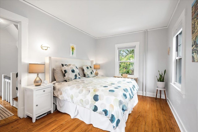 bedroom with light wood finished floors and baseboards