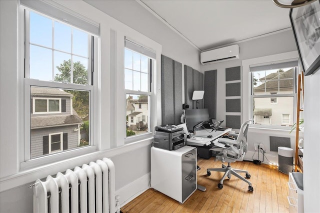 office featuring radiator, a wall mounted air conditioner, hardwood / wood-style floors, and a healthy amount of sunlight